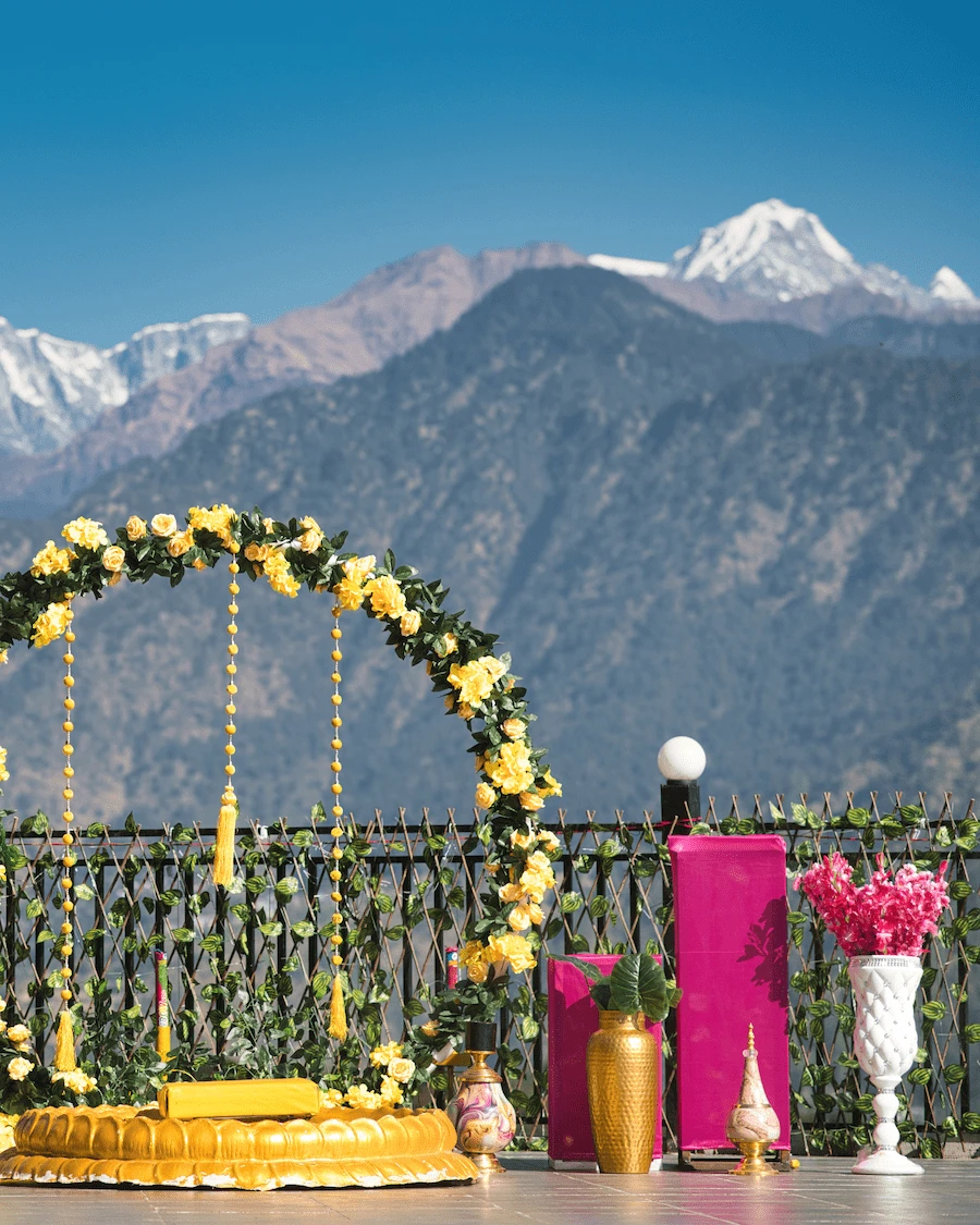 Outdoor destination wedding decor with floral rings and golden seating
