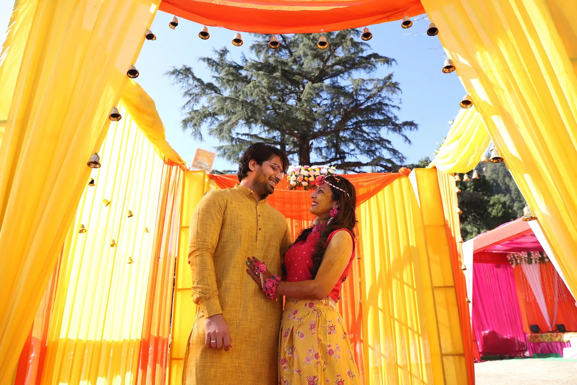 Couple in a yellow draped haldi setup planned by Wedding Planner Dehradun