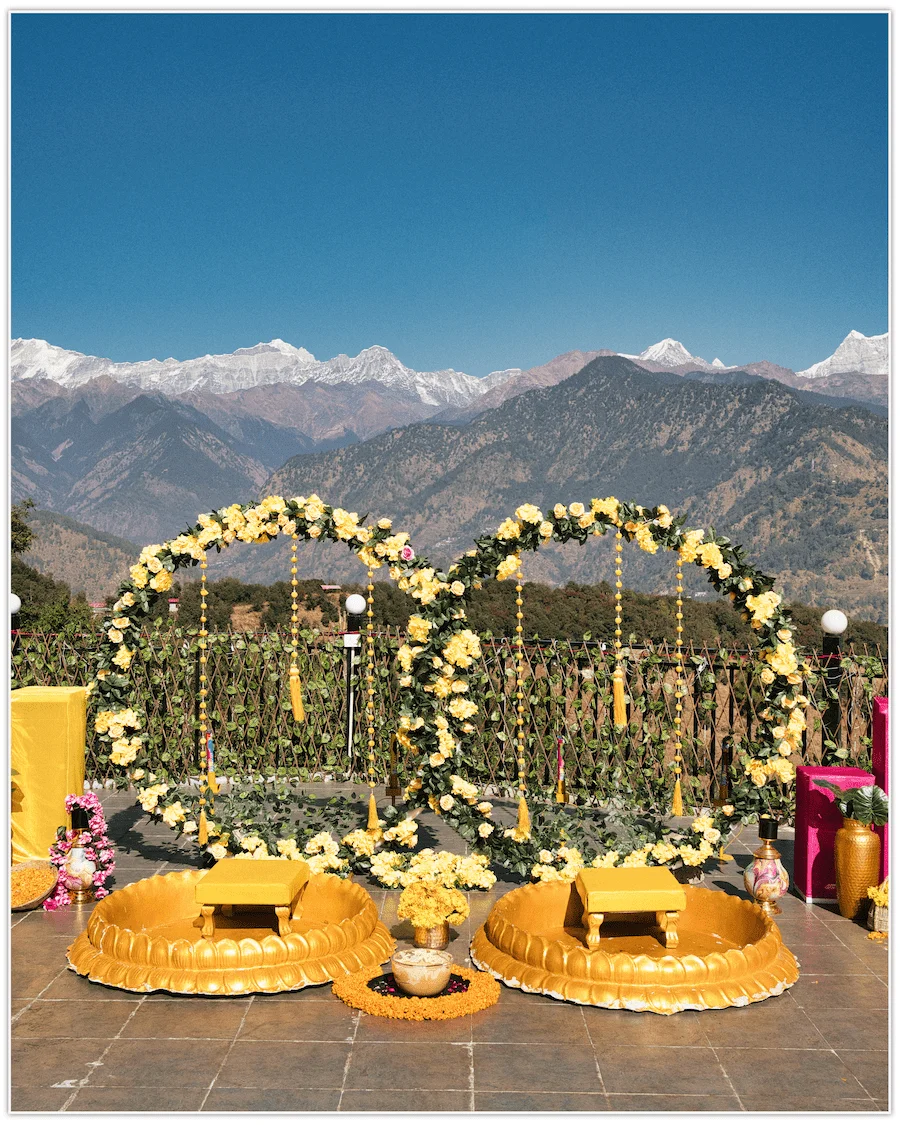 Wedding event stage decoration with yellow floral arches and Himalayan backdrop